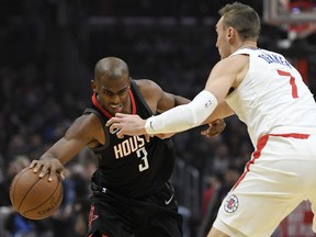Houston Rockets guard Chris Paul, left, tries to drive by Los Angeles Clippers forward Sam Dekker during the first half of an NBA basketball game, Monday, Jan. 15, 2018, in Los Angeles.