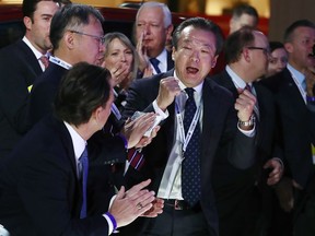 Toshiaki Mikoshiba, center, president and CEO of American Honda Motor Co., reacts after the 2018 Honda Accord won car of the year during the North American International Auto Show, Monday, Jan. 15, 2018, in Detroit.
