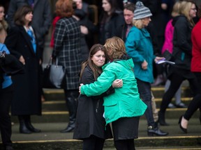 Friends and family console each other while leaving the funeral of Chloe and Aubrey Berry at Christ Church Cathedral in Victoria, B.C., on Friday January 12, 2018.
