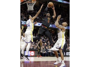 Cleveland Cavaliers' Dwyane Wade (9) passes against Golden State Warriors' Shaun Livingston (34) and David West (3) in the first half of an NBA basketball game, Monday, Jan. 15, 2018, in Cleveland.