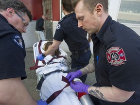 Firefighters and BC Ambulance paramedics in Vancouver take a woman who suffered an fentanyl and heroin overdose to the hospital, in January, 2018.