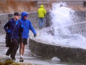 Walkers and cyclists brave the weather on the seawall near Dundarave Park.