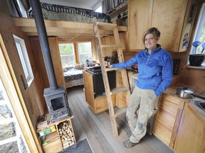Kayla Feenstra with the 128 square-foot home she built and lives in it in Abbotsford, BC, Saturday, January 31, 2015.