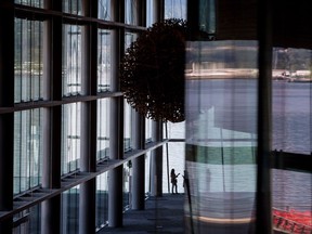 Two women are silhouetted as they talk at a window overlooking the harbour at the Vancouver Convention Centre on Sept. 20, 2017.