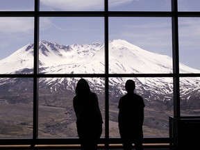 A series of small earthquakes has rattled an area northeast of Mount St. Helens in southwest Washington state. In this May 14, 2010, file photo, visitors peer out of display windows at the volcano at the Johnston Ridge Observatory at Mount St. Helens National Volcanic Monument, near Toutle, Wash.