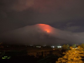 In this Sunday, Jan. 14, 2018, photo provided by Earl Recamunda, an orange glow is seen at the cloud-shrouded crater of Mayon volcano at Legazpi city, Albay province, about 340 kilometers southeast of Manila, Philippines. The Philippines' most active volcano rumbled back to life Sunday with lava rising to its crater in a gentle eruption that has prompted authorities to evacuate thousands of villagers.