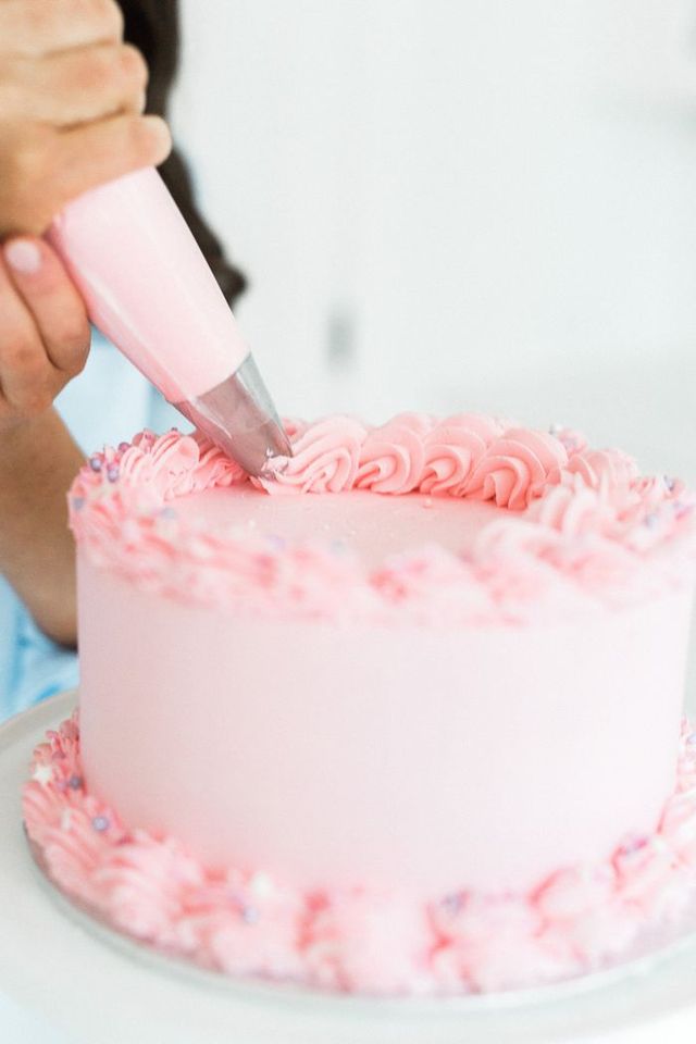 Tessa Sam of Sweet Bake Shop pipes icing onto a cake. 