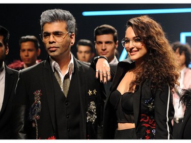 Indian Bollywood film director Karan Johar (L) and actress Sonakshi Sinha (R) showcase creations by designer Falguni Shane Peacock at the Lakmé Fashion Week (LFW) Summer Resort 2018 in Mumbai on February 2, 2018.