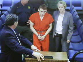 Hector Romero Assistant Public Defender (L) and Melisa McNeill, Public Defender (R) are seen on screen at the first appearance in court for high school shooting suspect Nikolas Cruz (C) on February 15, 2018 at Broward County Court House in Fort Lauderdale, Florida.