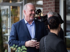 B.C. Premier John Horgan, who is trying not to fuel a trade war with Alberta, leaves a North Vancouver coffee shop on Thursday after announcing changes to the province's minimum wage.