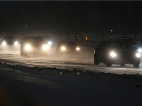 Traffic moves through blowing snow on Memorial Drive. Up to 35 cm of snow could fall in before the storm ends.