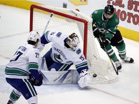 Jacob Markstrom gets to the puck before Dallas Stars center Devin Shore.