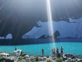 Hikers cool off in the icy waters of British Columbia's Berg Lake in this September 2017 photo. Cradled below towering mountains at the centre of Vancouver Island is a lake whose name tells the landscape's history. Landslide Lake caught the face of one the Island's tallest mountains when a magnitude-7.3 earthquake shook it loose in 1946.