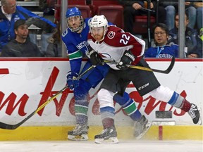 Colin Wilson of the Colorado Avalanche checked Christopher Tanev of the Vancouver Canucks into the boards during their game on Jan. 30 at Rogers Arena in Vancouver.