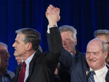 Andrew Wilkinson and Mike de Jong raise their hands after Wilkinson was was elected leader at the BC Liberal party leadership convention at the vote at the BC Liberal party leadership convention, Vancouver, February 03 2018.