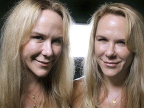 In this Oct. 12, 2011, file photo, Anastasia, left, and Alexandria Duval, known as Alison and Ann Dadow before they changed their names, stand in the window of their yoga studio in West Palm Beach, Fla. Alexandria Duval, who was accused of deliberately driving off a Hawaii cliff and killing her identical twin sister, has been acquitted of murder.