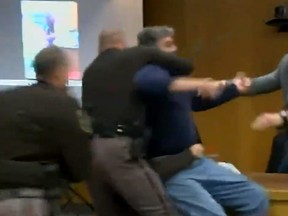 Randall Margraves is held back by bailiffs after he lunges at Larry Nassar.