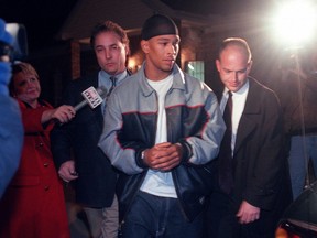Rae Carruth is escorted to a waiting car in Jackson, Tennessee, following his arrest by FBI agents in this Dec 15, 1999 photo.