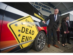 Minister of Public Safety and Solicitor General Mike Farnworth looks at a forfeited Range Rover SUV at Queen Elizabeth Secondary School in Surrey Thursday. Surrey RCMP will have the seized vehicle at its disposal to fight gang crime in the city.
