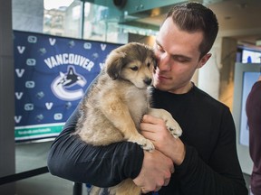 Vancouver Canucks Bo Horvat cuddles a puppy during Cupcakes and Cuddles fundraiser for the SPCA at Telus Garden.