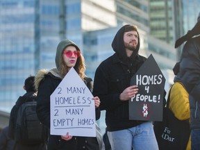 Demostrators hold signs on Sunday during a Vancouver rally calling for action on affordable housing.