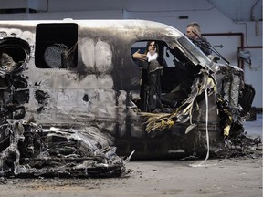 FILE PHOTO - Corinna and Alex Robic, the parents of Matthew Robic the co-pilot who died in Northern Thunderbird Air plane crash on a road outside  outside YVR, in October 2012, here inside a hanger as the family survey the wreckage in Richmond on April 25, 2012.