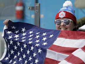 A fan waves the U.S. flag during the women's curling match at the 2018 Winter Olympics in Gangneung, South Korea, Monday, Feb. 19, 2018. (AP Photo/Aaron Favila) ORG XMIT: OLYCU123