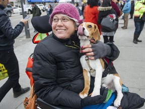 Josee Menard, holding Toby in Vancouver on Thursday, talks about the difficulties of current transportation options for the disabled, after an all-party B.C. government committee was unanimous in supporting ride-hailing services.