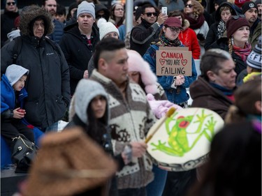A woman holding a sign and others listen during a rally for Tina Fontaine in Vancouver, B.C., on Saturday February 24, 2018. A man accused of killing a 15-year-old Indigenous girl and dumping her body in Winnipeg's Red River was found not guilty of second-degree murder this week.Tina Fontaine's remains were discovered eight days after she was reported missing in August 2014.