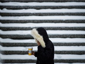 A woman walks through a snow covered plaza in downtown Vancouver, B.C., on Friday February 23, 2018.
