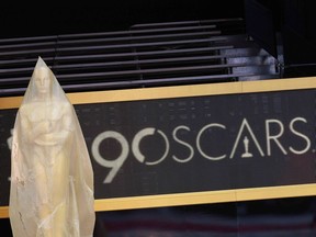 An Oscar statue on the red carpet is protected by plastic sheeting during heavy rain in Hollywood, California, on March 2, 2018. The 90th Academy Awards will take place on Sunday.