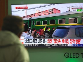 A man watches a television news report about a suspected visit to China by North Korean leader Kim Jong Un, at a railway station in Seoul on March 27, 2018. J