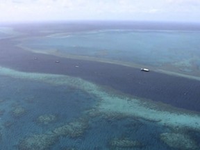 In this image made from Thursday, March 22, 2018, video, an aerial view shows boats a the scene of a helicopter crash at the Great Barrier Reef in Queensland, Australia.