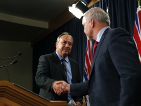 Premier John Horgan and Green Party Leader Andrew Weaver shake hands as they speak to media following the legislation announcement banning union and corporate donations to political parties during a press conference at Legislature in Victoria, B.C., on Monday, September 18, 2017.