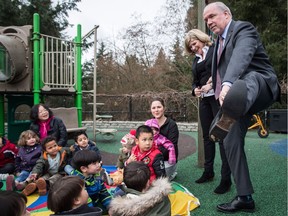 B.C. Premier John Horgan shows his socks to children at a Coquitlam daycare while standing with facility manager Susan Hall-Ford before a child care announcement on Wednesday March 28, 2018.