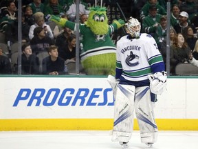 Stars mascot Victor E Green reacts to a call of no-goal, after video review, as Vancouver Canucks goalie Jacob Markstrom looks on during an NHL game in Dallas on Feb. 11.