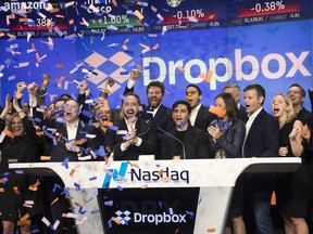 Dropbox CEO Drew Houston and Dropbox co-founder Arash Ferdowsi, centre, celebrate the launch of Dropbox's initial public offering as they ring the opening bell at Nasdaq on Friday.