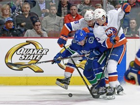 Brock Boeser tries to split the Islanders' defenders Monday night in Vancouver.