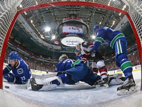 Alex Edler looks on as Clayton Keller of the Coyotes scores against the Canucks at Rogers Arena on Wednesday night.