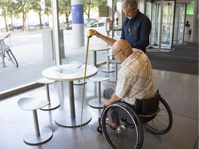 Rick Hansen Foundation's Accessibility Certification professionals,  Rod Bitz (in the wheelchair) and Uli Egger, conduct an accessibility rating   [PNG Merlin Archive]