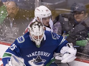 Arizona Coyotes right-winger Josh Archibald tries to squeeze behind Canucks goalie Jacob Markstrom during third-period NHL action in Vancouver on March 7.