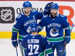 Vancouver Canucks centre Henrik Sedin (33), of Sweden, centre Sam Gagner (89) and left wing Daniel Sedin (22), of Sweden, celebrate Gagner's goal against the Edmonton Oilers during the second period of an NHL hockey game in Vancouver, B.C., on Thursday March 29, 2018.