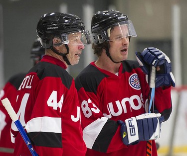 Rockers Barney Bentall (left) and his son Dustin chat as Juno Cup players take to the ice for a practice at the Bill Copeland Sports Centre in Burnaby on March 22, 2018.