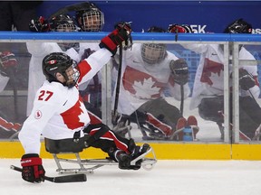 Canada's Brad Bowden celebrates with teammates after Canada's goal during an ice sledge hockey game between Canada and Czech Republic at the 2014 Winter Paralympics in Sochi, Russia.