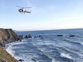 This photo provided by the California Highway Patrol shows a helicopter hovering over steep coastal cliffs Tuesday, March 27, 2018, near Mendocino, Calif., where a vehicle plunged about 100 feet off a cliff along Highway 1, killing all five passengers.