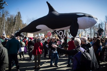 A man carries a likeness of an orca whale as thousands of people participate attend a rally after marching together during a protest against the Kinder Morgan Trans Mountain pipeline expansion in Burnaby, B.C., on Saturday March 10, 2018. Indigenous leaders and environmentalists beat drums and sang as they protested Kinder Morgan's $7.4-billion Trans Mountain pipeline in southern B.C. Saturday morning. The pipeline is set to increase the capacity of oil products flowing from Alberta to the B.C. coast to 890,000 barrels from 300,000 barrels.