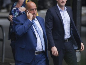 Accused fraudster Mark Chandler (left) crosses the street on his way back to B.C. Supreme Court Friday, Sept. 8, 2017 to attend his extradition hearing.