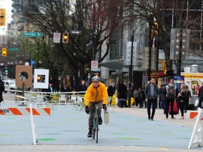 A cyclist rides through the 800-block Robson Street in Vancouver Tuesday. NPA Coun. Melissa De Genova's motion to reopen that block to bus traffic to combat 'illegal marijuana vending' was ruled out of order.