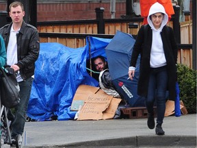 A man peers out of a makeshift shelter on Cambie Street in Vancouver Wednesday as city officials announce they expect the 2018 homeless count to show an increase in people living on the streets.