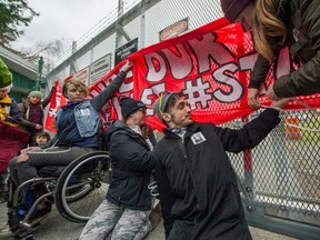 Protesters against Kinder Morgan's pipeline expansion attach themselves to the gate before being arrested in front of Kinder Morgan Canada gates in Burnaby  on March 20.